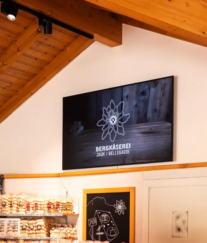 Exemple de contenu sur-mesure diffusé via une solution Hubgrade. Écran d’affichage dynamique dans une fromagerie artisanale, illustrant un contenu visuel personnalisé conçu par Hubgrade