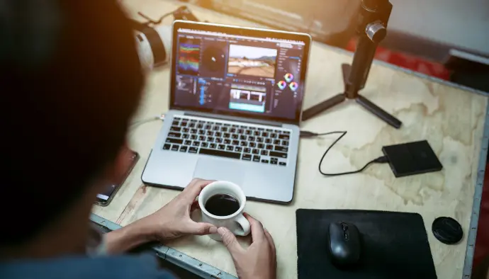 Une création de contenu simple, rapide et efficace Travail de création graphique sur un ordinateur portable avec une tasse de café à la main.