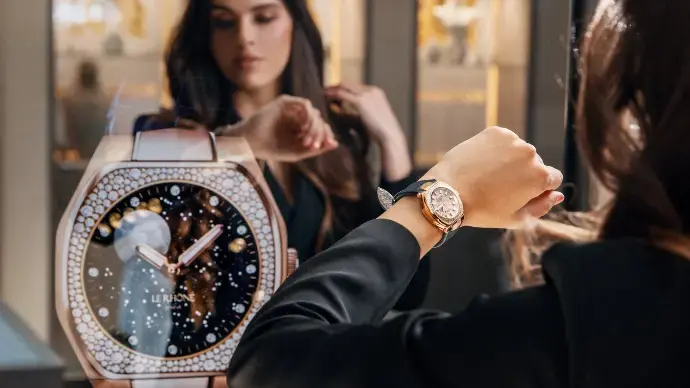 Miroir digital affichant une montre de luxe tout en reflétant la cliente qui l’essaie