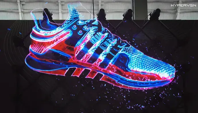Hologramme 3D HYPERVSN représentant une chaussure flottant dans l’air avec des effets lumineux bleus et rouges